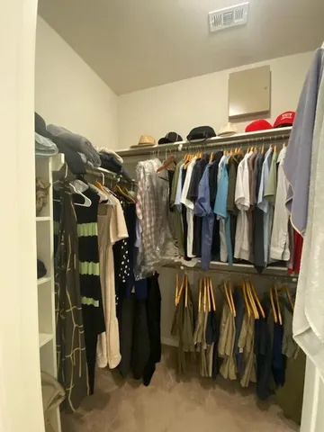 a view of walk in closet with clothes and shoes