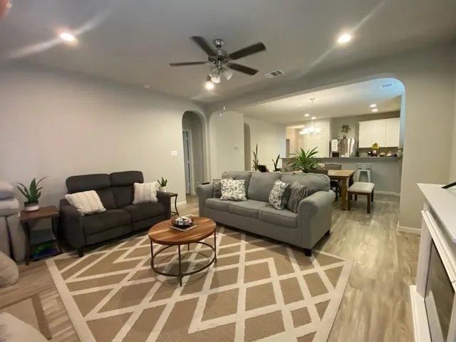 a living room with furniture and a ceiling fan