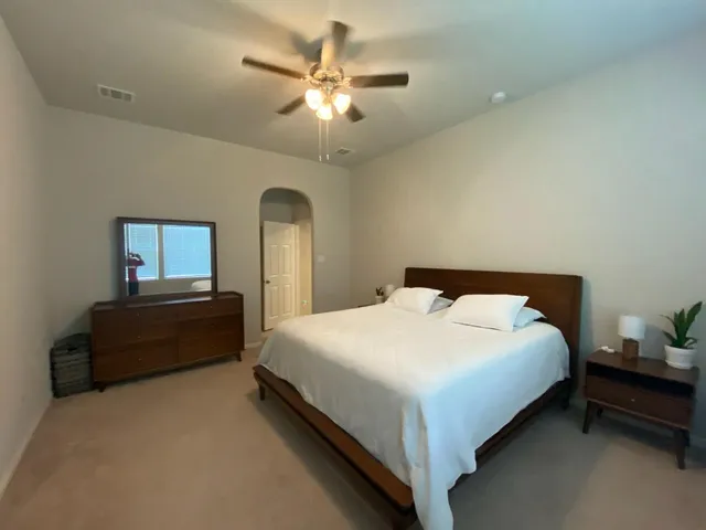 a large bed sitting in a bedroom next to a window