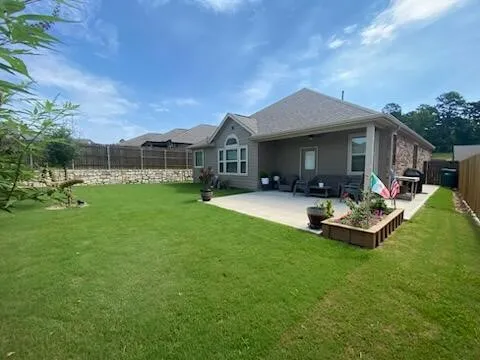 a front view of a house with a garden and trees