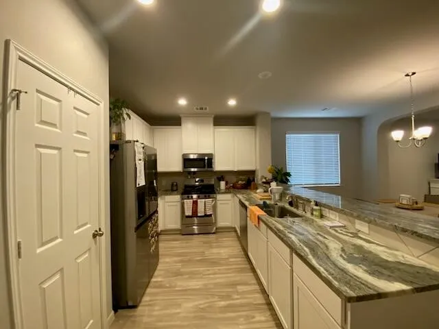 a kitchen with stainless steel appliances a refrigerator sink and stove