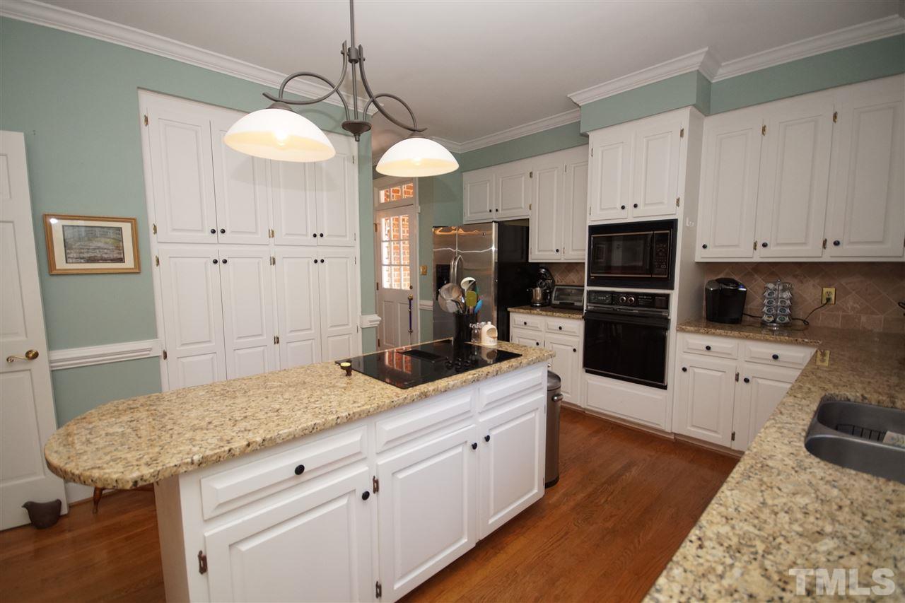1217 Weldon Place Raleigh, NC 27608 - Photo 11 of 24 a kitchen with granite countertop a sink a counter space appliances and cabinets