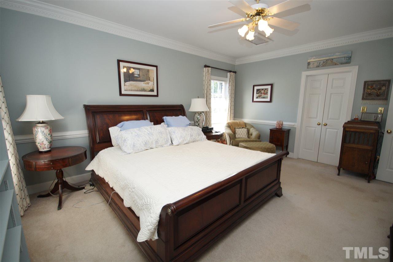 1217 Weldon Place Raleigh, NC 27608 - Photo 13 of 24 a spacious bedroom with a bed and a chandelier