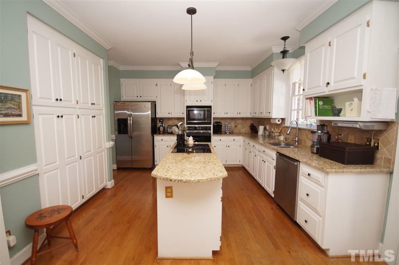 1217 Weldon Place Raleigh, NC 27608 - Photo 10 of 24 a kitchen with stainless steel appliances kitchen island granite countertop a sink a stove a refrigerator a center island with cabinets