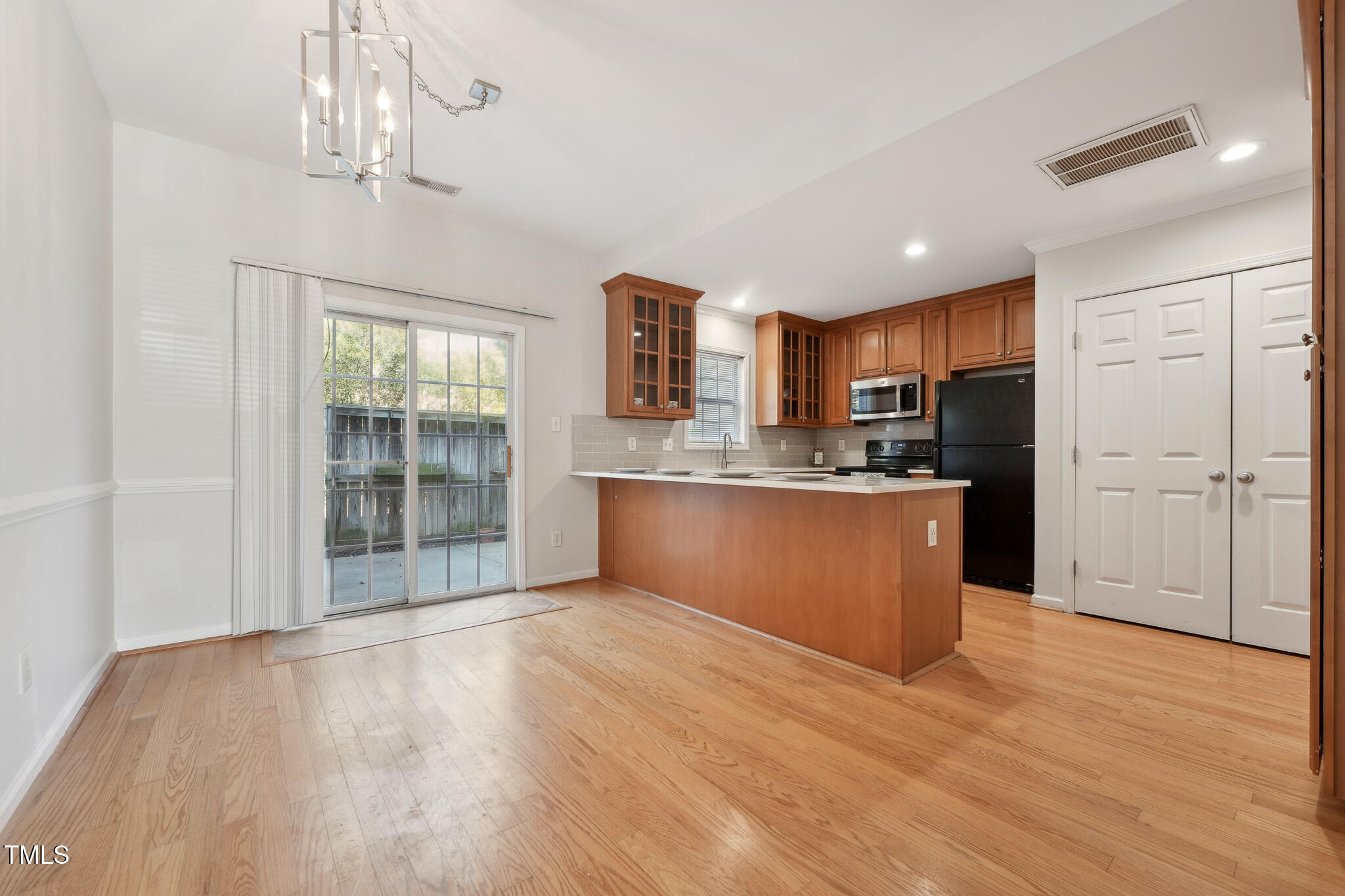 2031 Rivergate Road, Unit 105 Raleigh, NC 27614 - Photo 8 of 29 a kitchen with stainless steel appliances granite countertop a refrigerator a sink dishwasher a stove and a large window with wooden floor