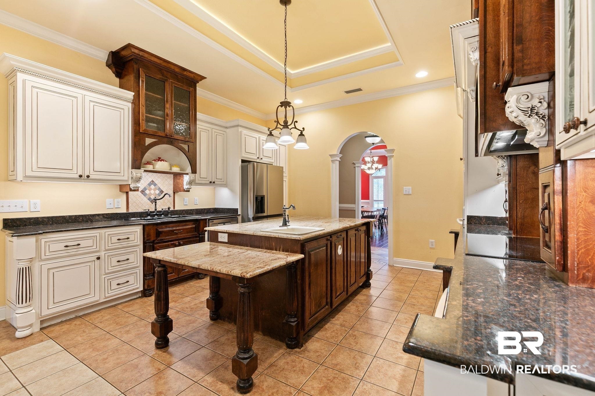 3668 Claridge Road North Mobile, AL 36608 - Photo 40 of 100 Kitchen with glass fronted cabinets, arched walkways, dark stone counters, pendant lighting, and dual tone cabinetry