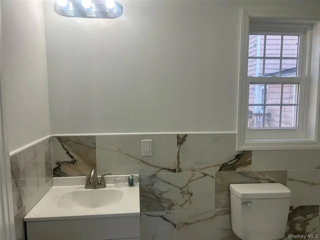 a kitchen with granite countertop white cabinets and refrigerator
