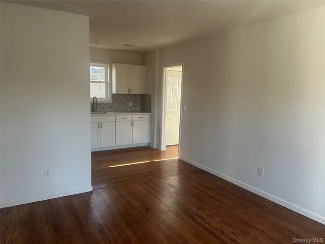 a kitchen with granite countertop white cabinets and refrigerator