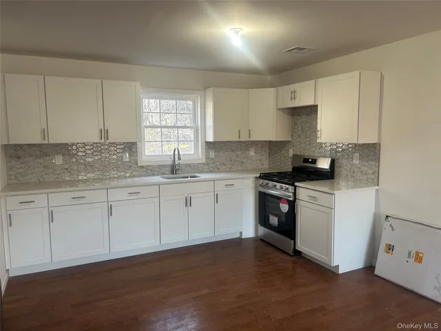 a kitchen with a refrigerator sink and cabinets