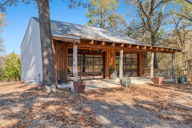 a view of a house with a large tree and wooden fence