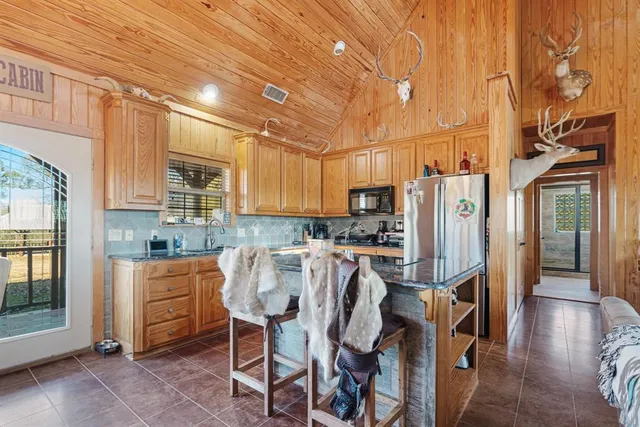 a kitchen with stainless steel appliances a refrigerator a stove a sink dishwasher and white cabinets with wooden floor