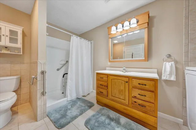 a view of house with a big yard and large trees