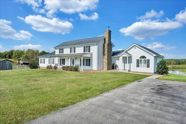 a view of a lake with lawn chairs and a big yard
