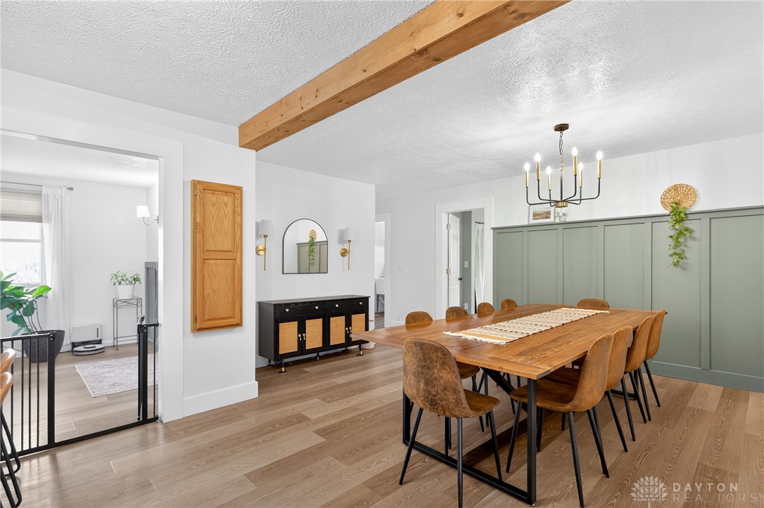 7888 Darke-Preble County Line Road Arcanum, OH 45304 - Photo 14 of 51 This spacious dining room features hardwood flooring, a striking chandelier, and an exposed wood beam.