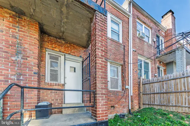 a view of a brick building next to a yard