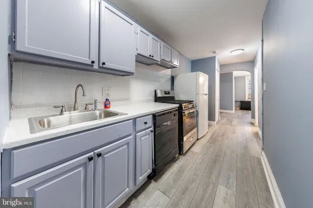 a kitchen with kitchen island granite countertop a sink stainless steel appliances and cabinets