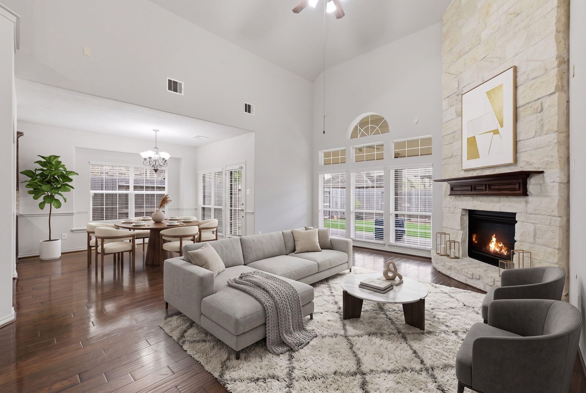 19903 Senterra Lakes Boulevard Spring, TX 77379 - Photo 7 of 50 Spacious living area with high ceilings, featuring a cozy stone fireplace and abundant natural light from large windows, seamlessly connected to an elegant breakfast space. this area is virtually staged.