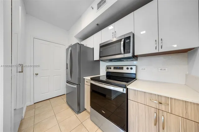 a kitchen with stainless steel appliances granite countertop a refrigerator microwave and sink
