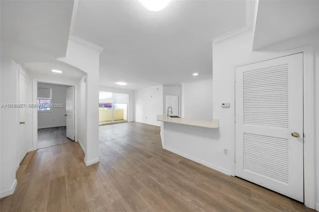 a view of a hallway with wooden floor and a cabinet