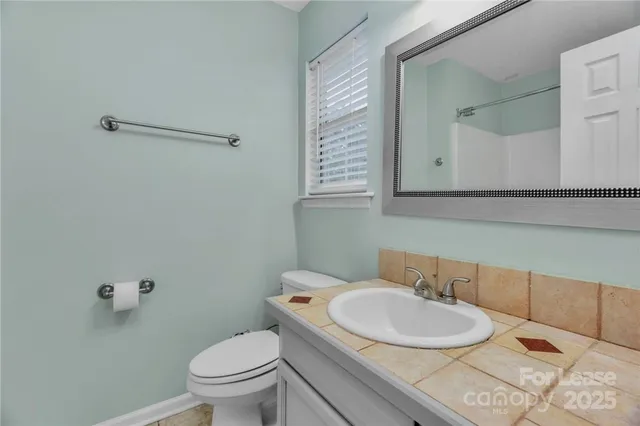 a bathroom with a toilet a sink and mirror