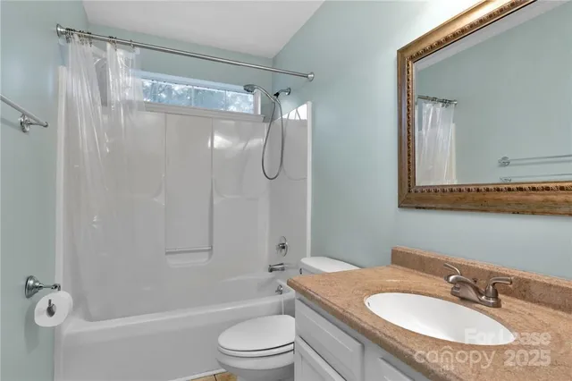 a bathroom with a granite countertop sink toilet a shower and a mirror