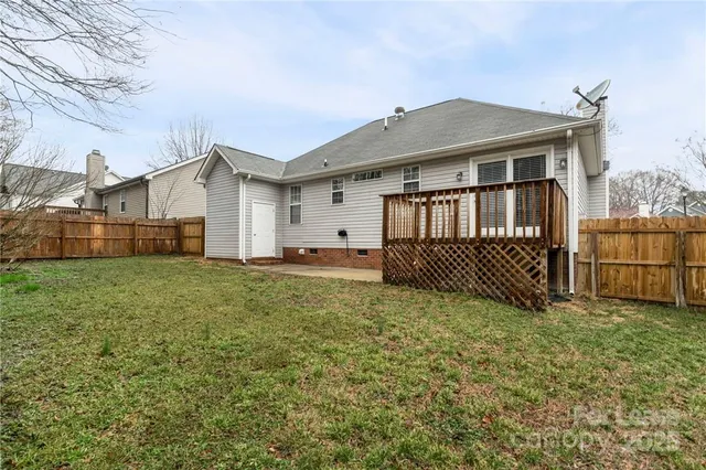 a view of a house with a yard and fence