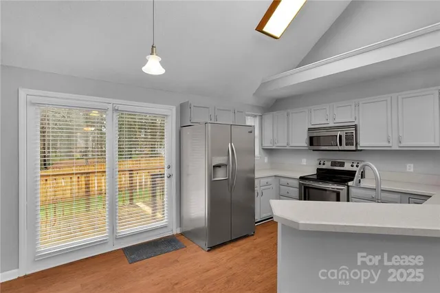 a kitchen with stainless steel appliances granite countertop a refrigerator a stove a sink and a microwave