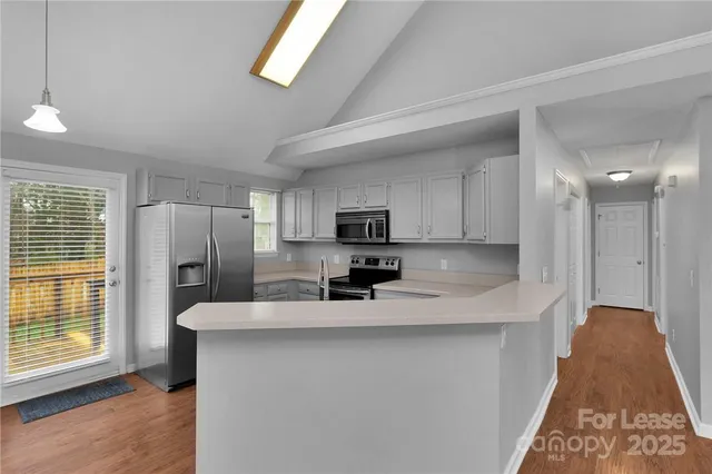 a kitchen with stainless steel appliances a refrigerator sink and microwave