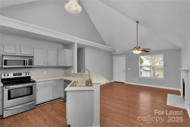 a kitchen with a sink appliances cabinets and a window