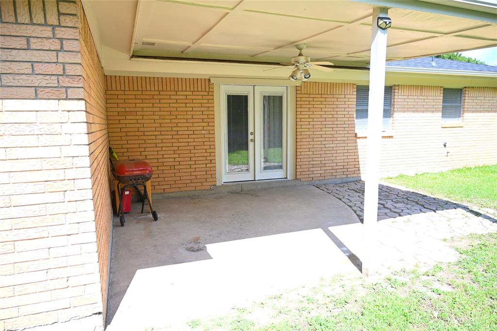 1352 Simpson Drive Hurst, TX 76053 - Photo 16 of 40 Covered patio featuring a ceiling fan, concrete slab, and an adjacent paver pathway