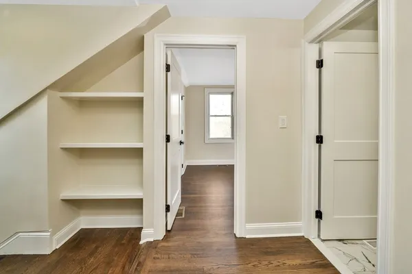 a view of a hallway with wooden floor