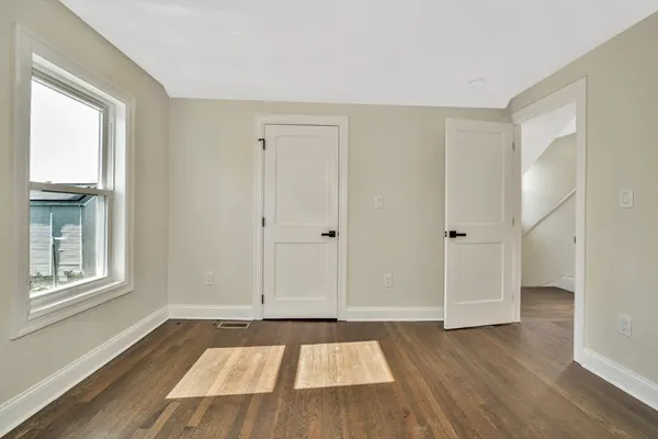 a view of an empty room window and wooden floor