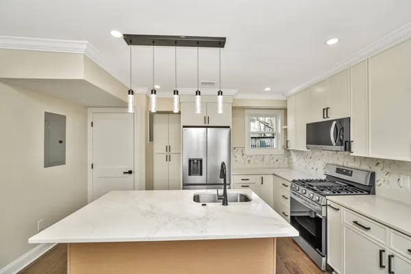a kitchen with stainless steel appliances a stove sink and refrigerator