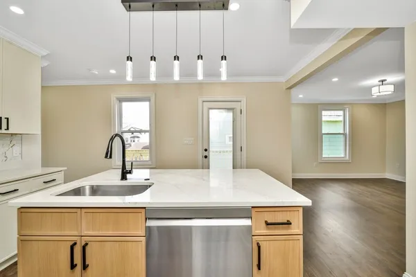 a kitchen with kitchen island granite countertop a sink and a stove