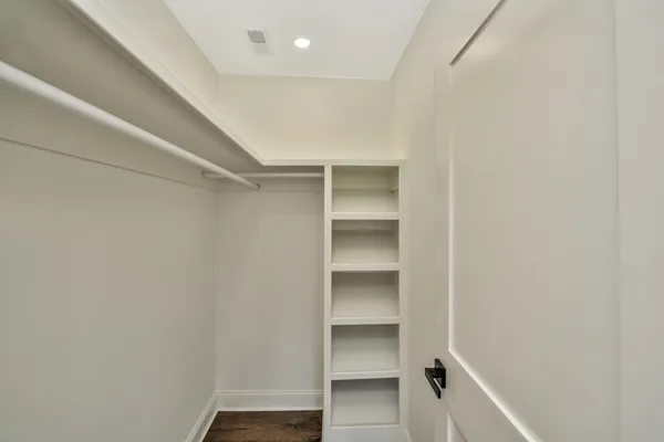 a view of walk in closet with empty racks