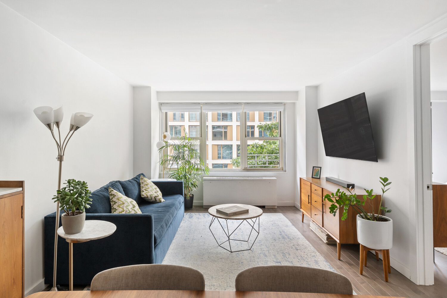 305 East 24th Street, Unit 3B Manhattan, NY 10010 - Photo 5 of 11 a living room with furniture and a flat screen tv