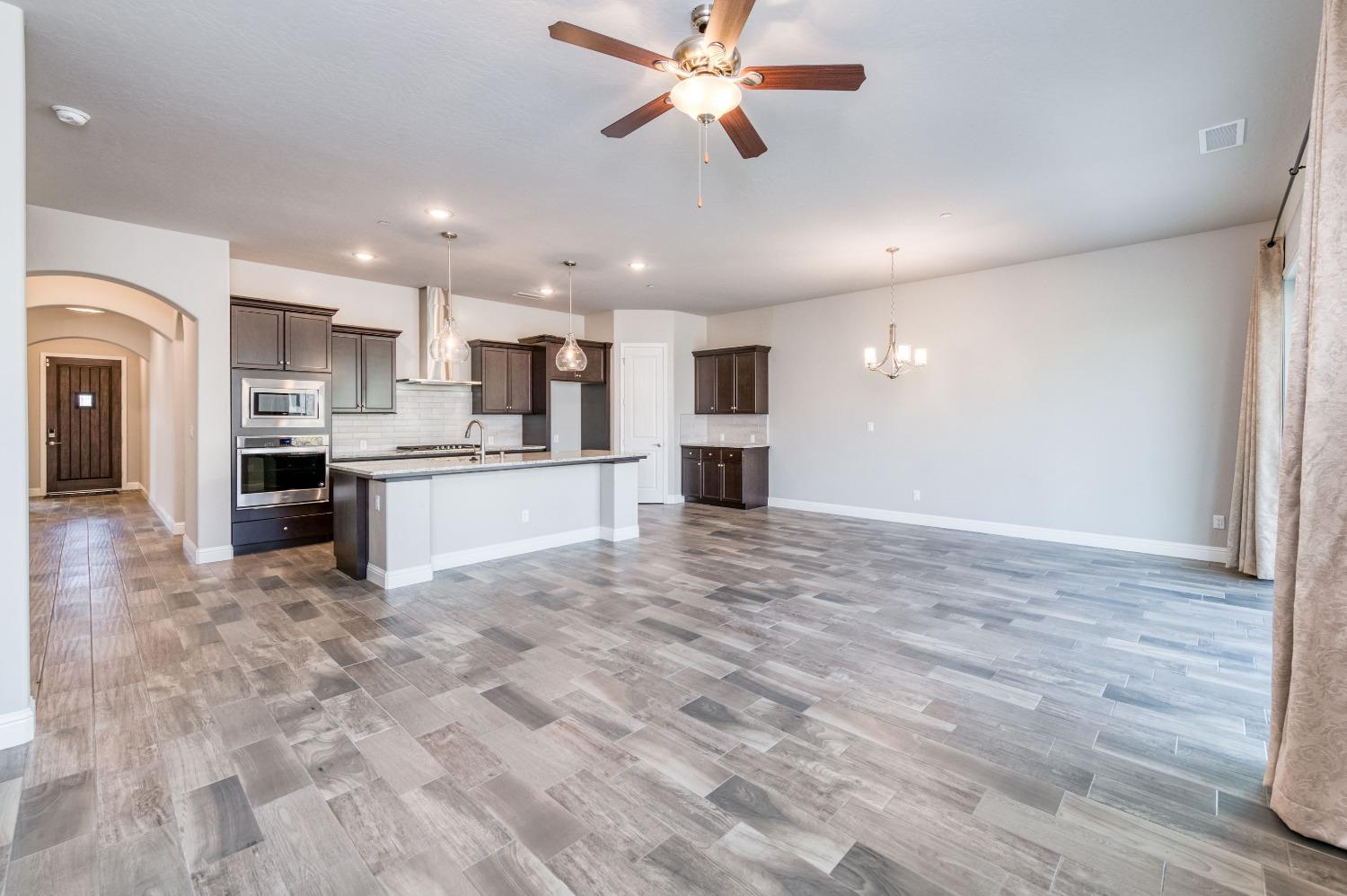 1729 North Carson Avenue Clovis, CA 93619 - Photo 11 of 38 a view of kitchen with kitchen island wooden floor center island and stainless steel appliances