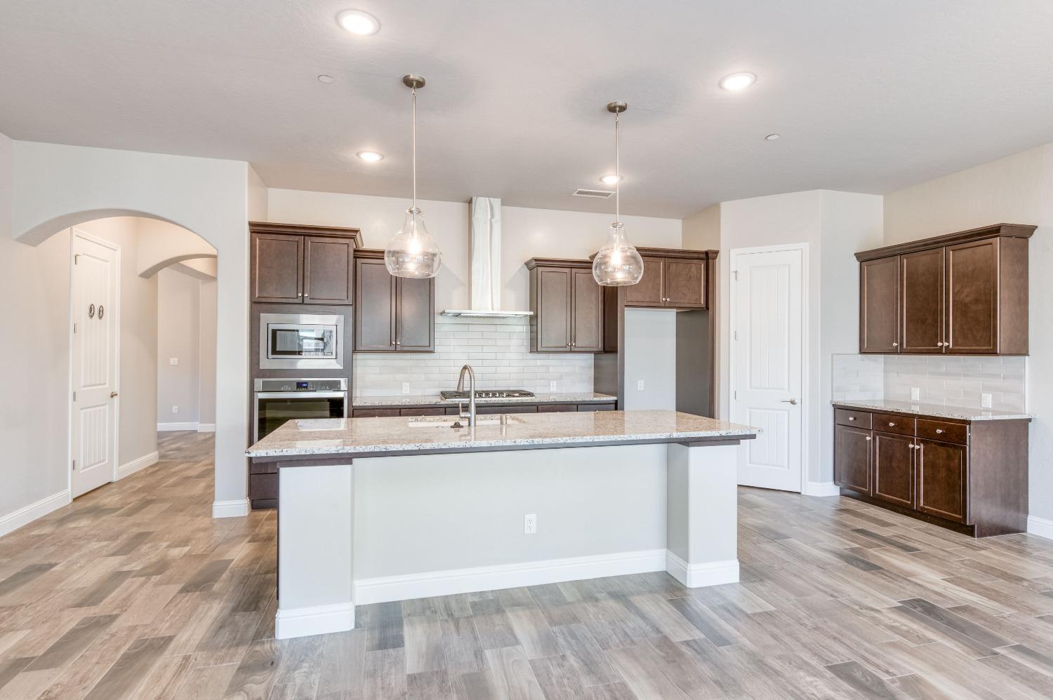 1729 North Carson Avenue Clovis, CA 93619 - Photo 13 of 38 a large kitchen with stainless steel appliances granite countertop a sink and cabinets