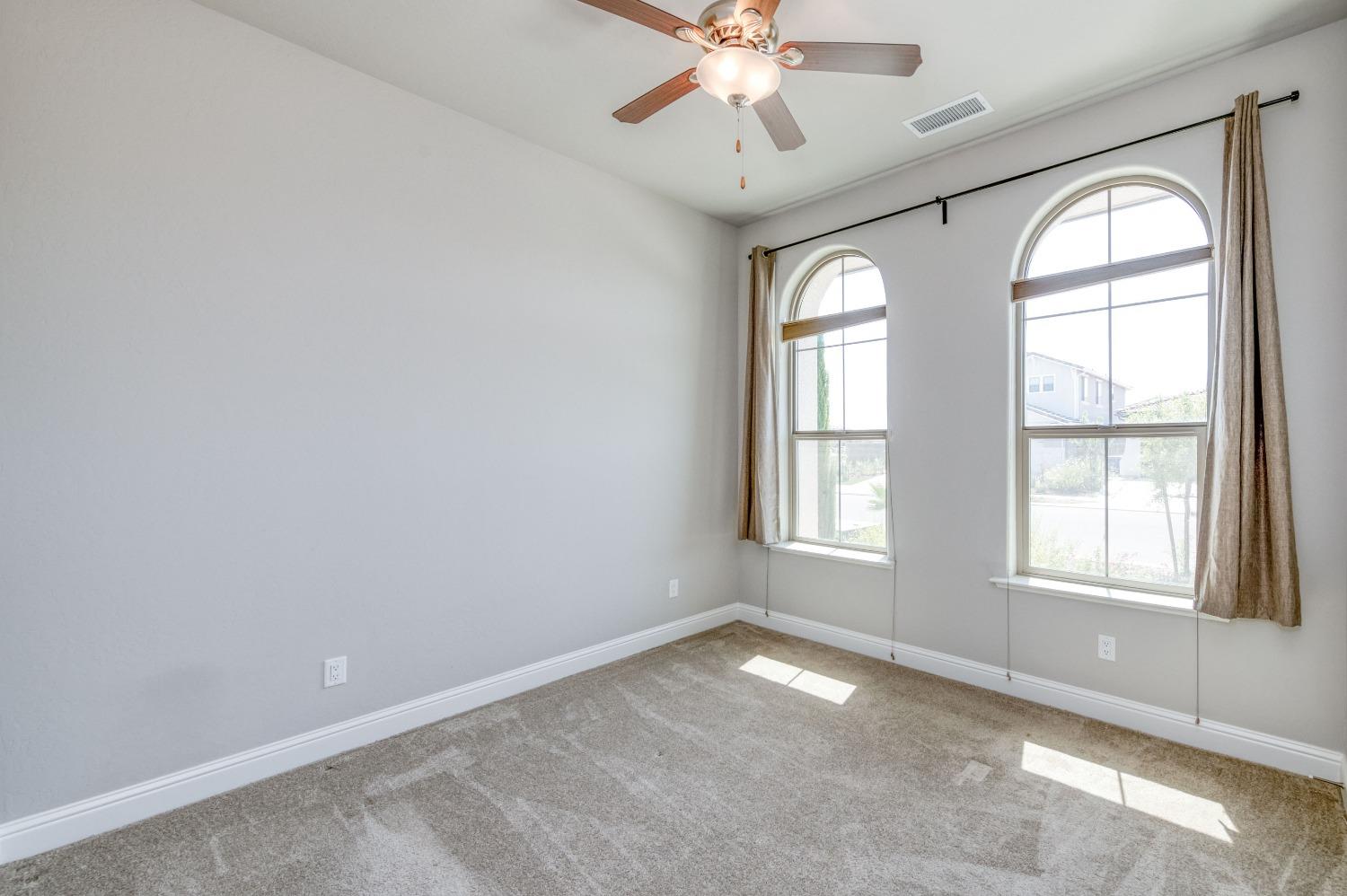 1729 North Carson Avenue Clovis, CA 93619 - Photo 19 of 38 an empty room with windows and chandelier fan
