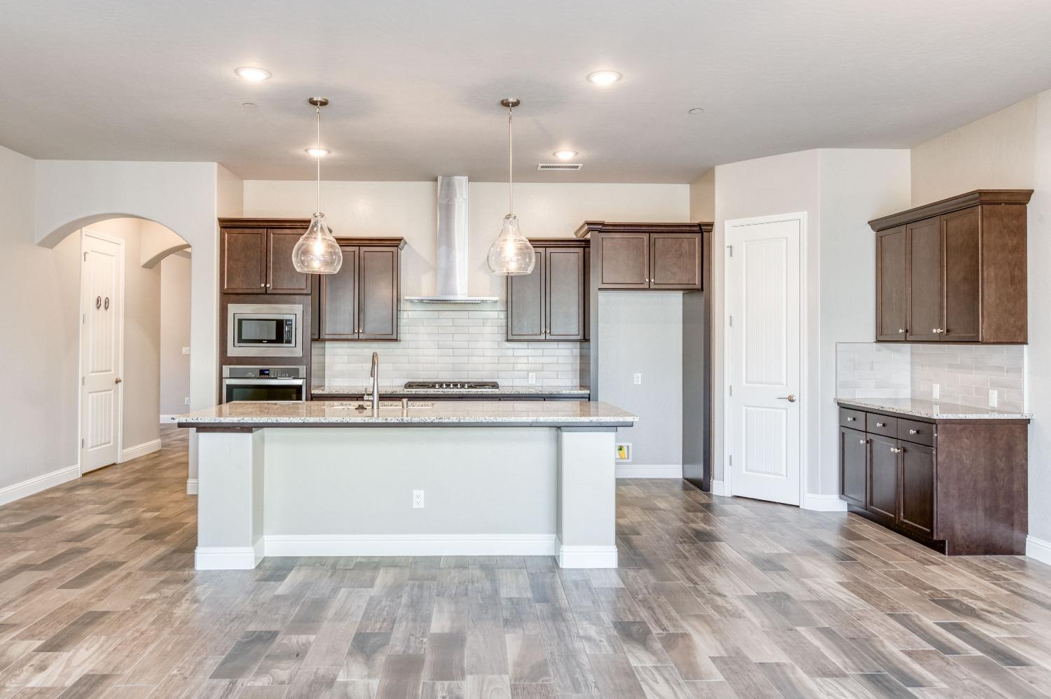 1729 North Carson Avenue Clovis, CA 93619 - Photo 2 of 38 a large kitchen with stainless steel appliances kitchen island granite countertop a stove and a sink