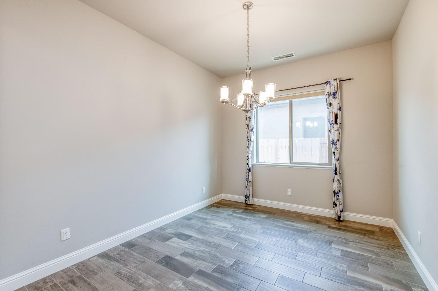 1729 North Carson Avenue Clovis, CA 93619 - Photo 22 of 38 an empty room with wooden floor and windows