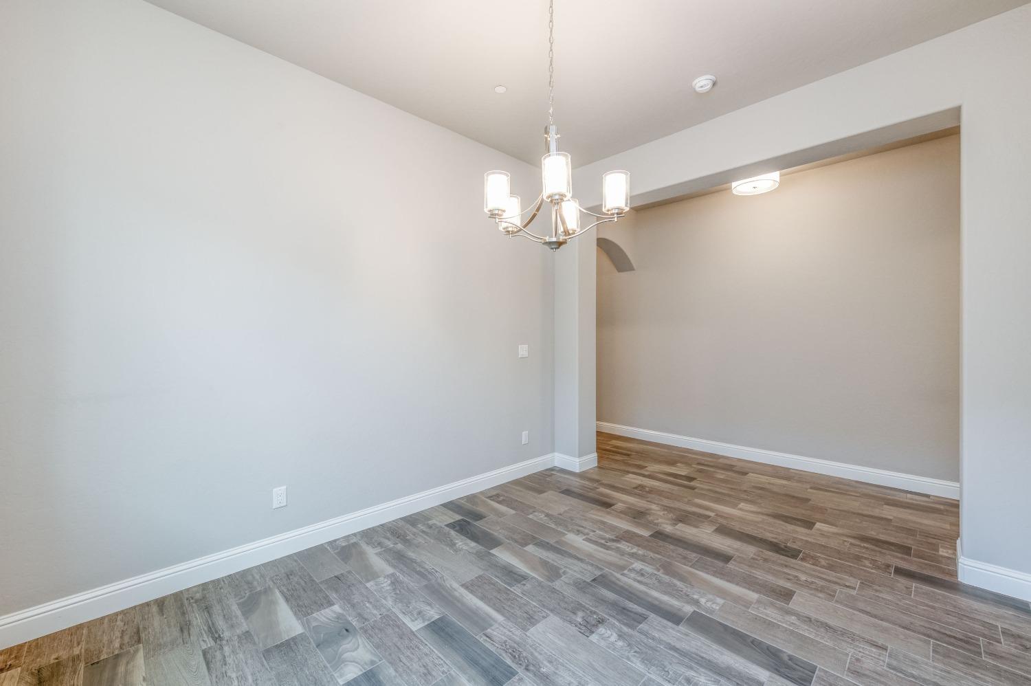 1729 North Carson Avenue Clovis, CA 93619 - Photo 23 of 38 an empty room with wooden floor and chandelier fan