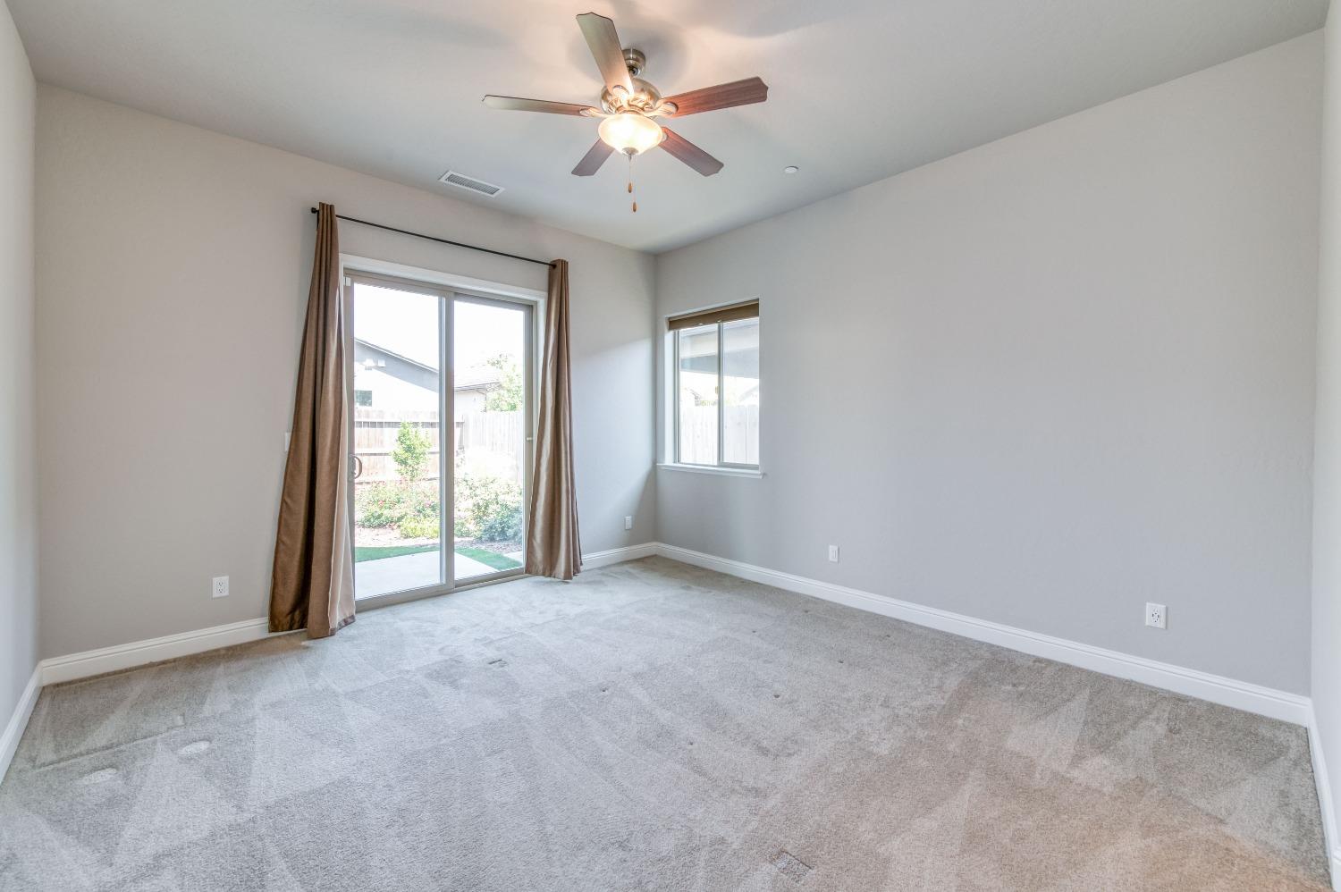 1729 North Carson Avenue Clovis, CA 93619 - Photo 24 of 38 an empty room with windows and chandelier fan