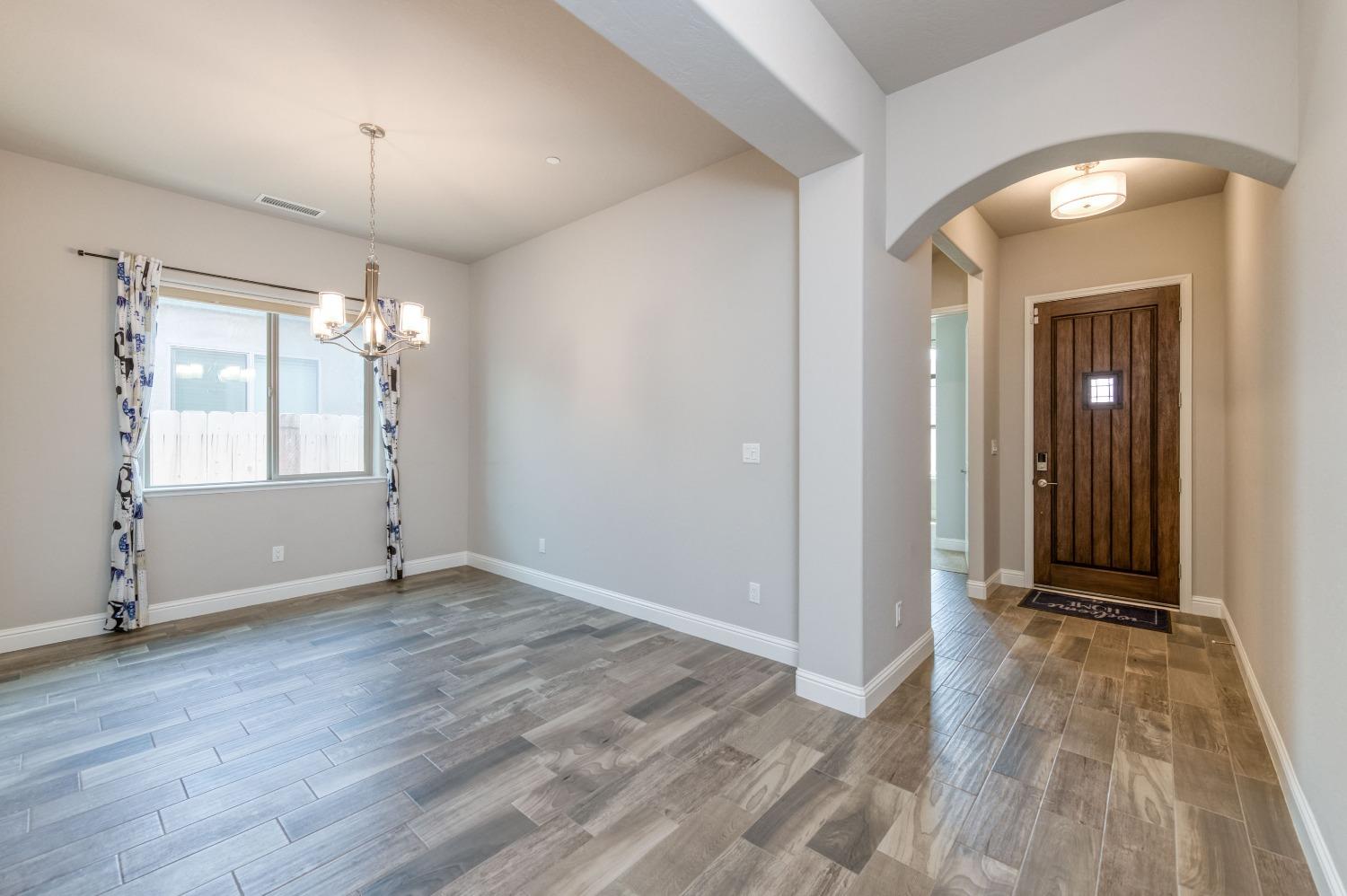 1729 North Carson Avenue Clovis, CA 93619 - Photo 8 of 38 an empty room with wooden floor and windows