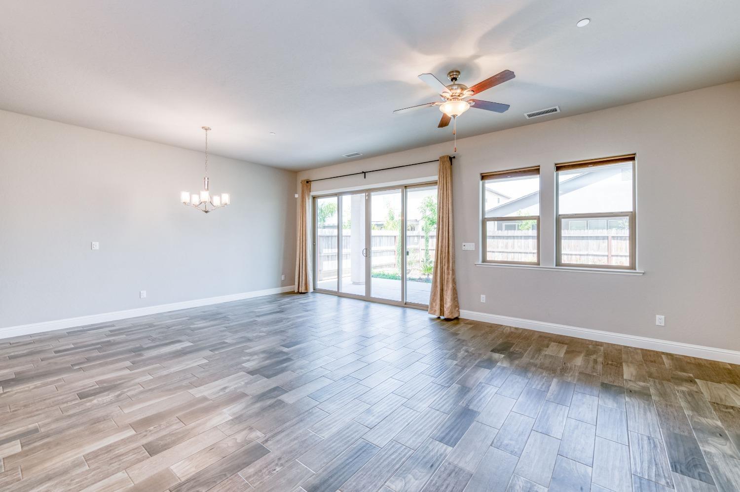 1729 North Carson Avenue Clovis, CA 93619 - Photo 10 of 38 a view of an empty room with wooden floor and a window