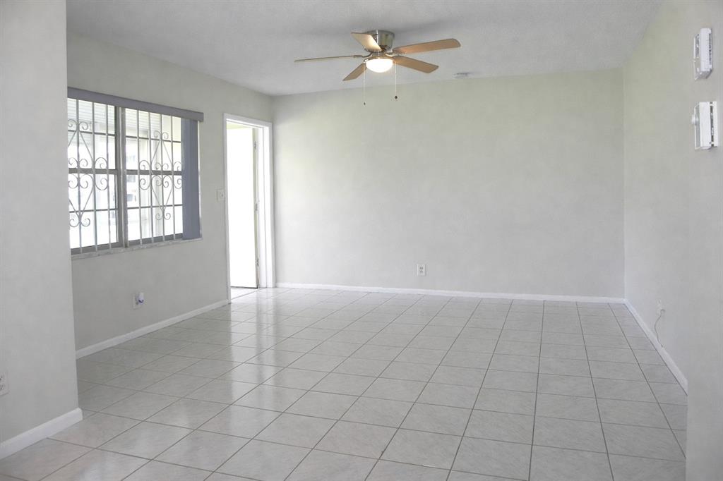 5300 Washington Street, Unit 107D Hollywood, FL 33021 - Photo 6 of 23 an empty room with chandelier fan and windows