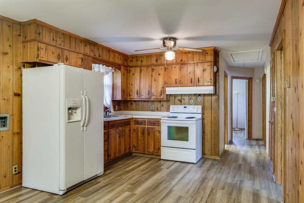 851 Reeves Road Antioch, TN 37013 - Photo 8 of 25 a kitchen with stainless steel appliances a refrigerator a stove a sink and white cabinets with wooden floor