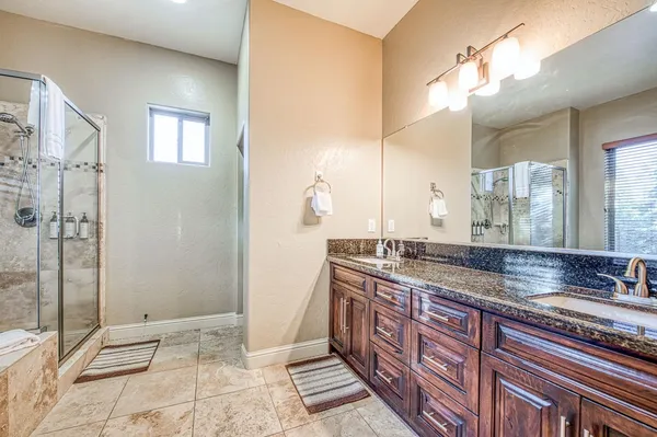 a bathroom with a granite countertop bathtub and shower