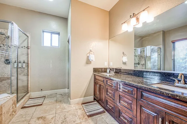 a bathroom with a granite countertop bathtub and shower