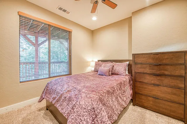 a bedroom with a bed and a flat tv screen next to a window